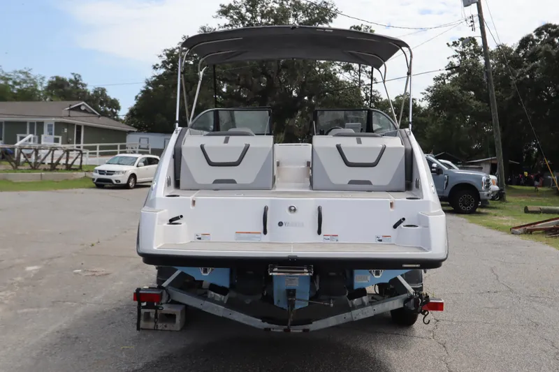 Slide: The Image of 2024 Yamaha Boats SX220 on trailer, rear view, parked outdoors. - 2