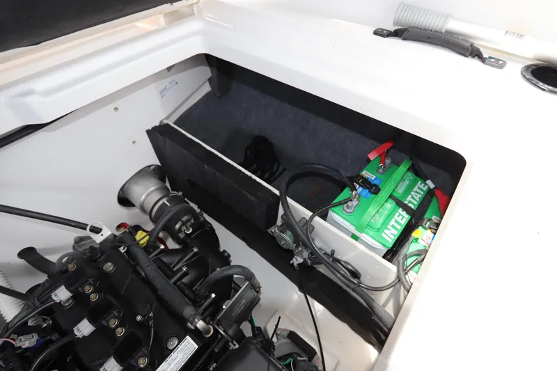 Slide: The Image of 2024 Yamaha Boats SX220 engine compartment with battery and wiring. - 25