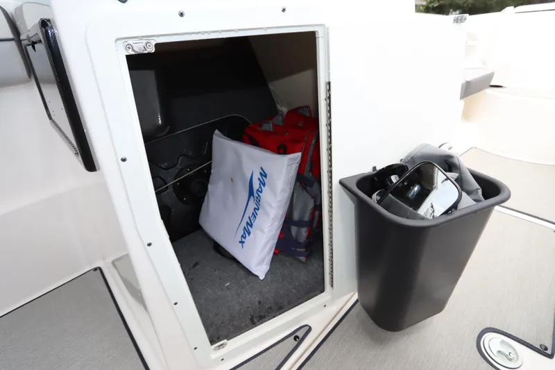 Slide: The Image of 2024 Yamaha Boats SX220 storage compartment with gear and accessories. - 28