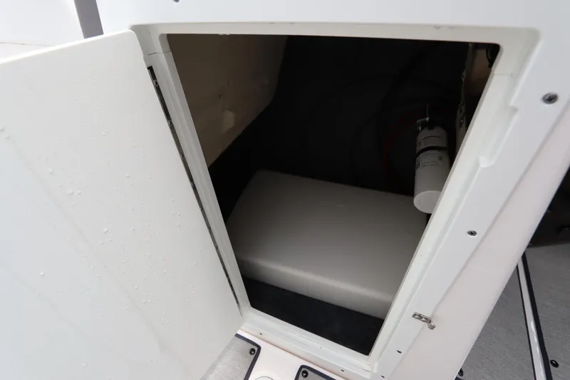 Slide: The Image of 2024 Yamaha Boats SX220 storage compartment with fire extinguisher. - 29