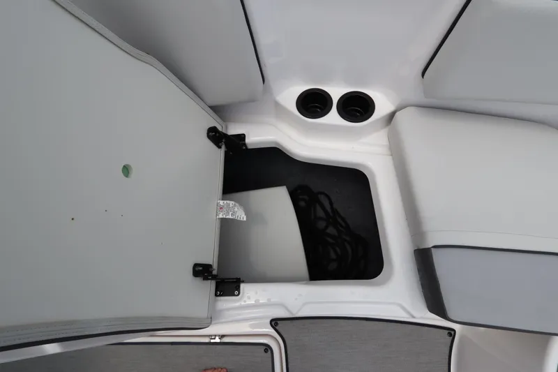 Slide: The Image of 2024 Yamaha SX220 boat storage compartment with open hatch and visible ropes. - 30