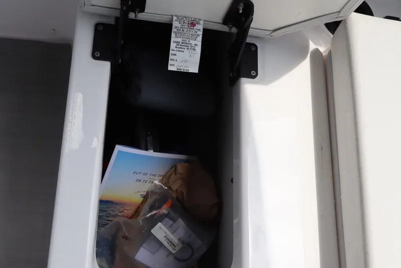 Slide: The Image of Storage compartment of 2024 Yamaha Boats SX220, containing documents and accessories. - 32