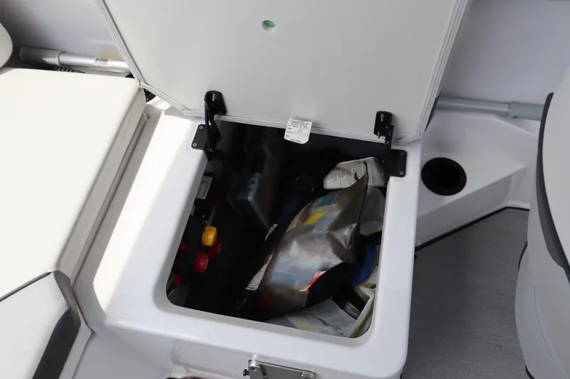 Slide: The Image of 2024 Yamaha Boats SX220 storage compartment with various items inside. - 33