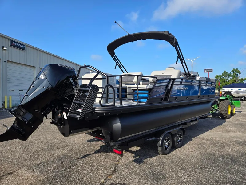 Slide: The Image of 2026 Starcraft CX23RL pontoon boat with Mercury outboard motor, parked on a trailer. - 4