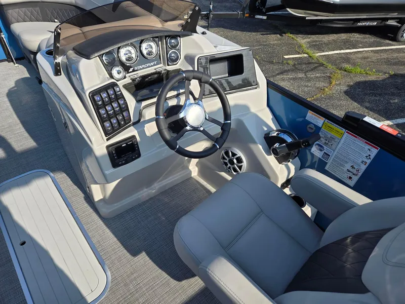 Slide: The Image of 2026 Starcraft CX23RL boat dashboard with steering wheel and control panel. - 8