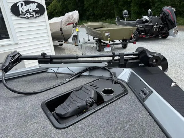 Slide: The Image of 2026 Vexus AVX181 boat with trolling motor, parked near other boats and trailers. - 7