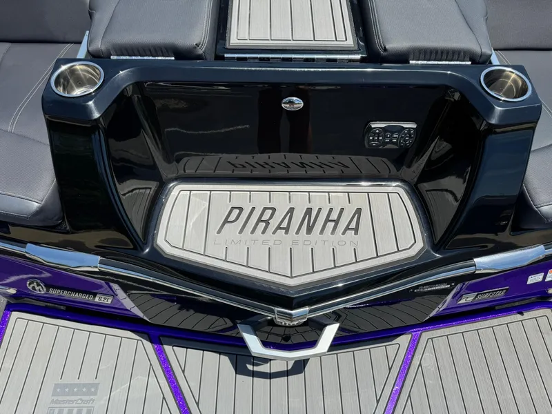 Slide: The Image of 2023 MasterCraft XStar S Piranha Limited Edition boat interior with cup holders and branding. - 19