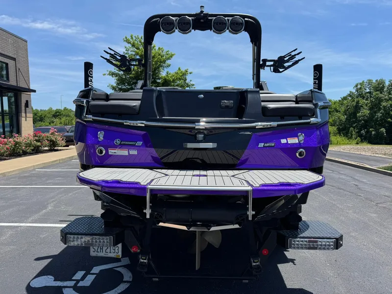 Slide: The Image of 2023 MasterCraft XStar S Piranha boat, rear view, parked outdoors on a sunny day. - 3