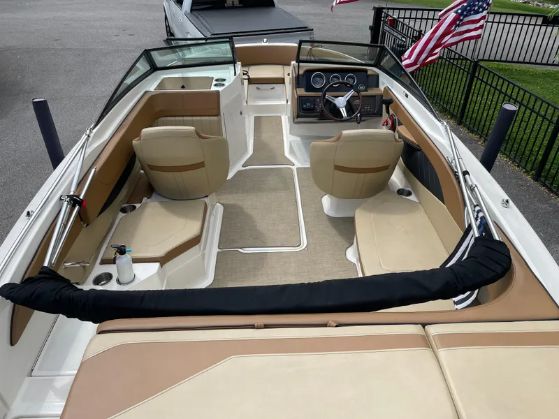 Slide: The Image of 2018 Sea Ray SPX 210 boat interior with beige seating and steering wheel. - 5