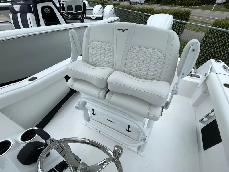 Slide: The Image of 2026 Tidewater 232 CC Adventure boat with luxurious white seating and steering wheel. - 17