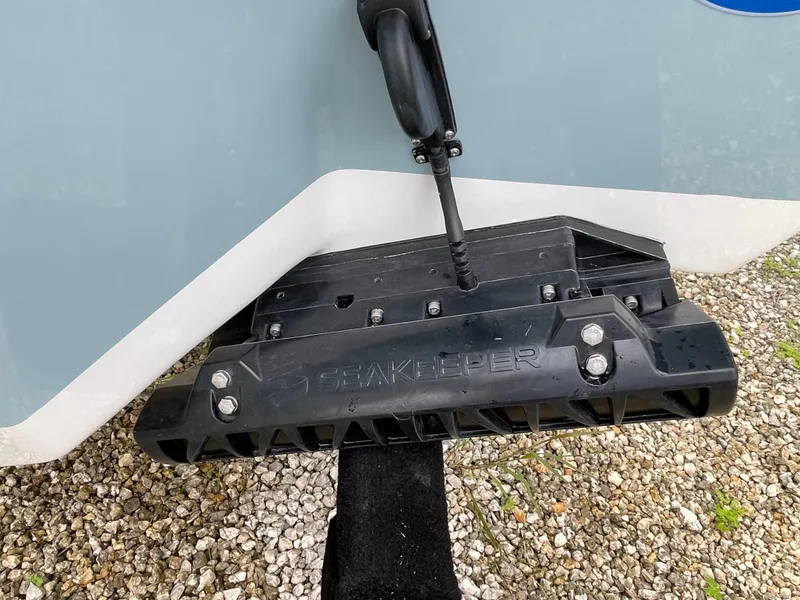 Slide: The Image of Seakeeper device on 2026 Tidewater 232 CC Adventure boat, resting on gravel. - 26