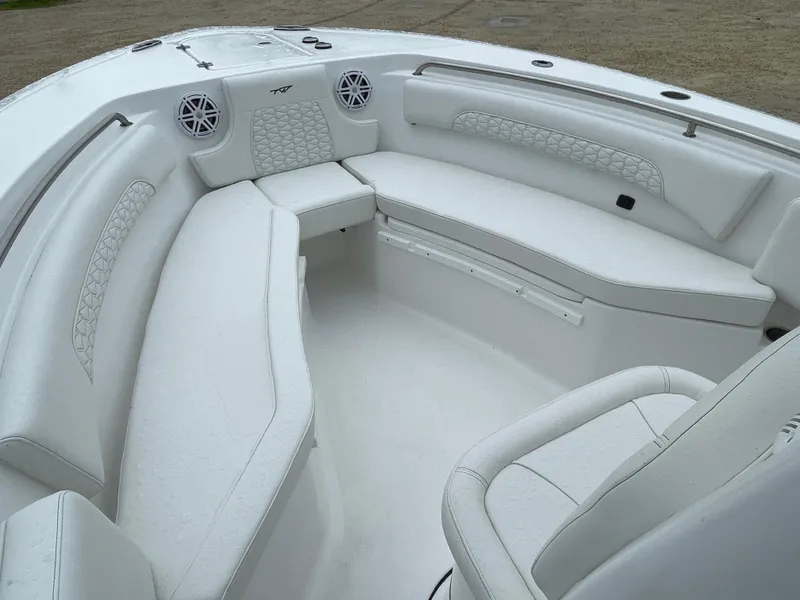 Slide: The Image of 2026 Tidewater 232 CC Adventure boat interior with white cushioned seating. - 6