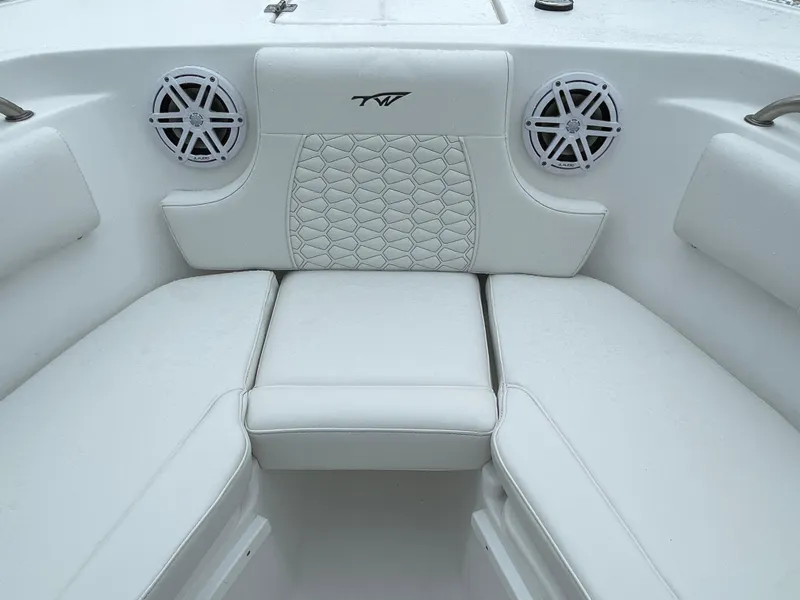 Slide: The Image of 2026 Tidewater 232 CC Adventure boat interior with white cushioned seating and speakers. - 7