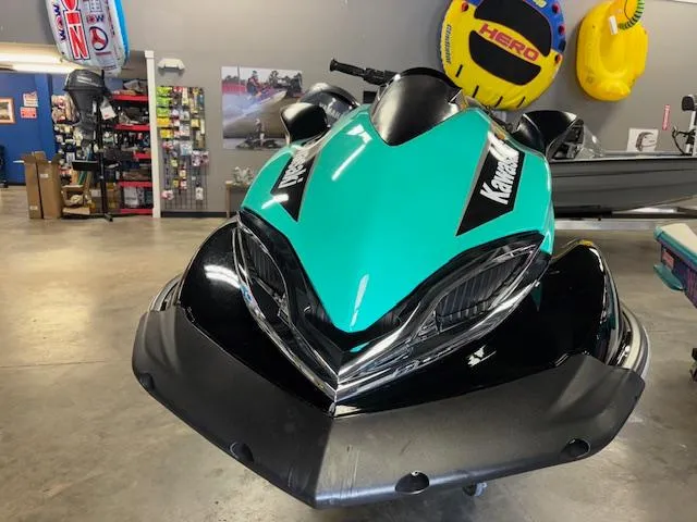 Slide: The Image of 2021 Kawasaki Ultra LX jet ski in showroom, vibrant teal and black design. - 3
