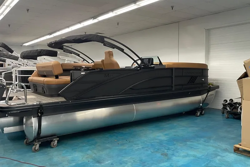 The Image of 2025 Bennington 22 M CRUISE pontoon boat in showroom, featuring sleek design and tan seating. - 0