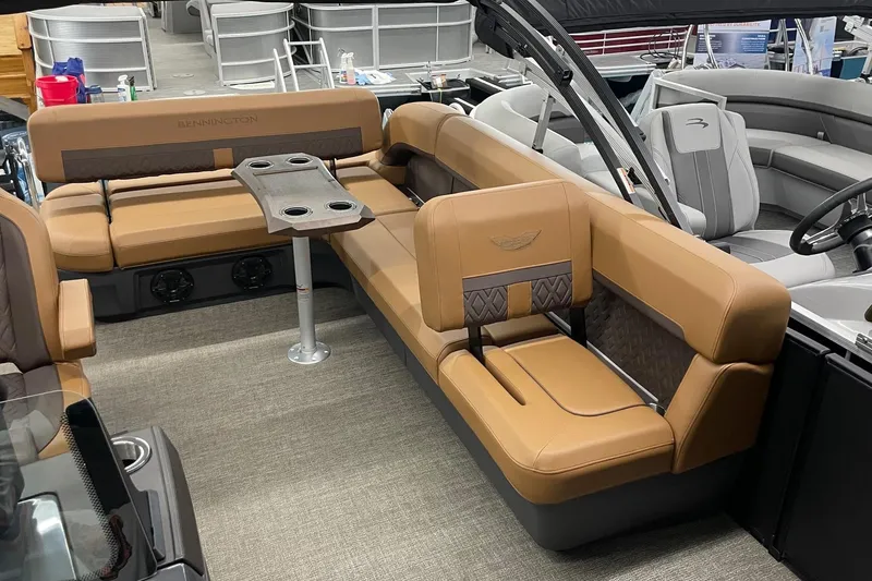 Slide: The Image of 2025 Bennington 22 M CRUISE boat interior with tan seating and cupholder table. - 5