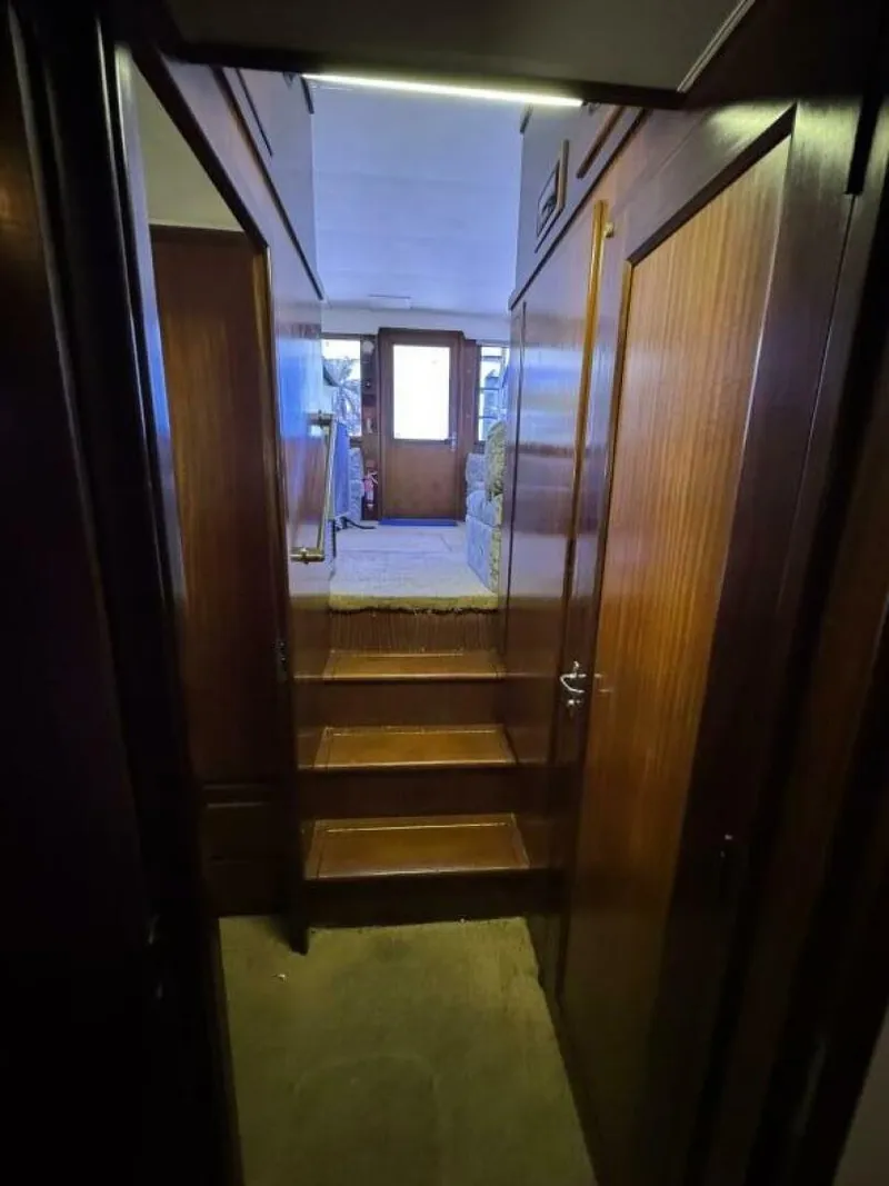 Slide: The Image of Interior view of 1989 Hatteras 42 Convertible yacht with wooden paneling and carpeted steps. - 12