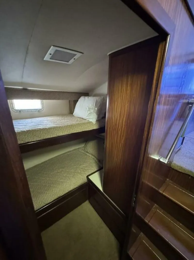 Slide: The Image of 1989 Hatteras 42 Convertible cabin with wooden interior and bunk beds. - 13