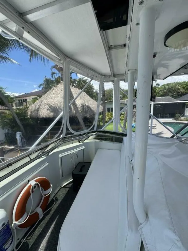 Slide: The Image of 1989 Hatteras 42 Convertible boat interior with seating and life preserver, tropical background. - 17