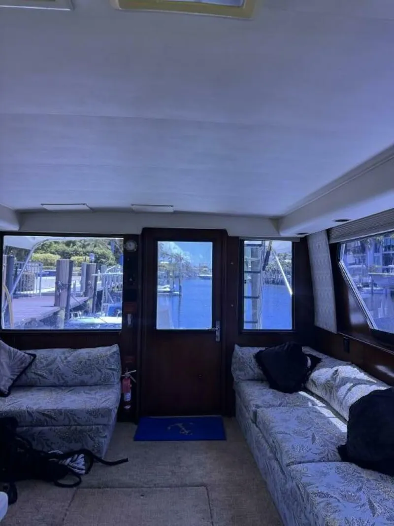 Slide: The Image of Interior of 1989 Hatteras 42 Convertible yacht with sofas and marina view. - 5