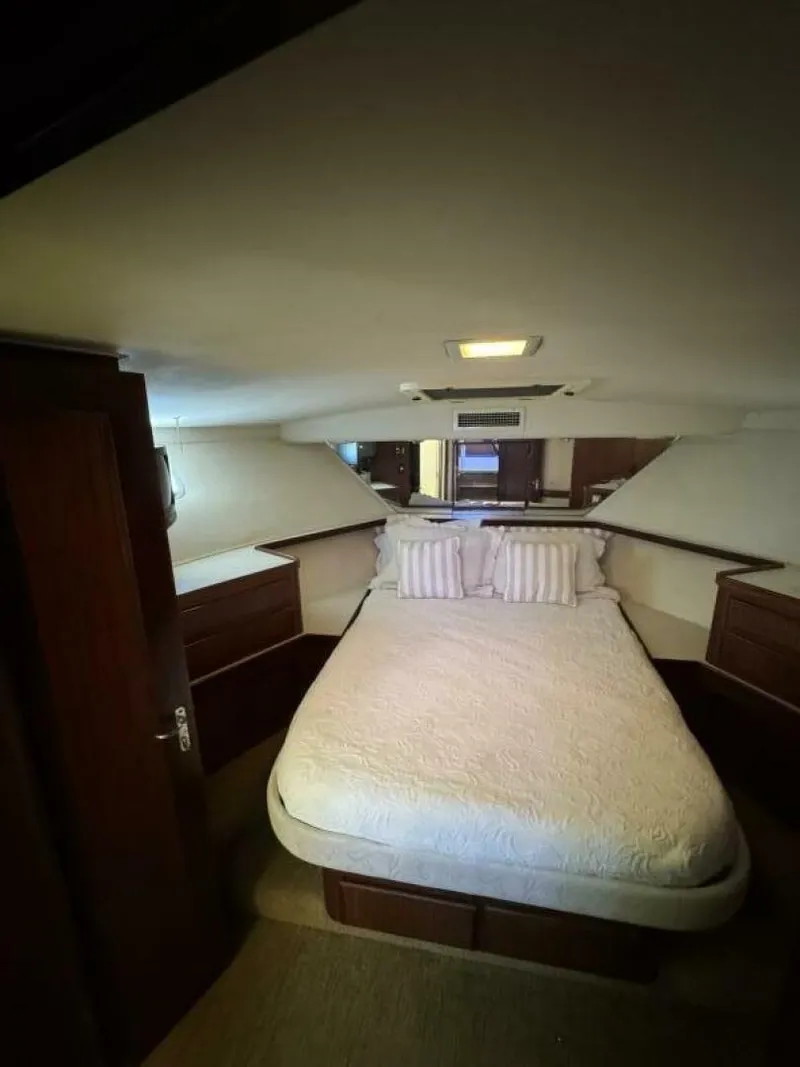 Slide: The Image of 1989 Hatteras 42 Convertible yacht bedroom with cozy bed and wooden cabinetry. - 9