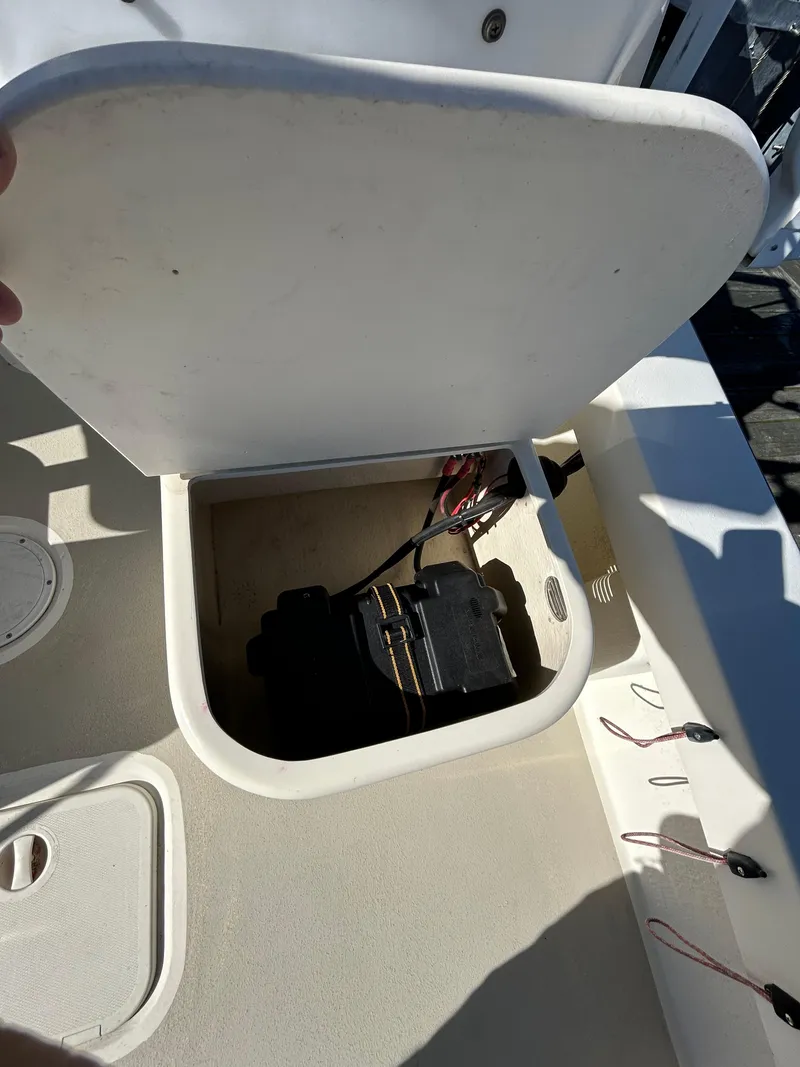 Slide: The Image of Open storage compartment on 2014 Seaway 21 Seafarer Cuddy boat, revealing battery and wiring. - 11