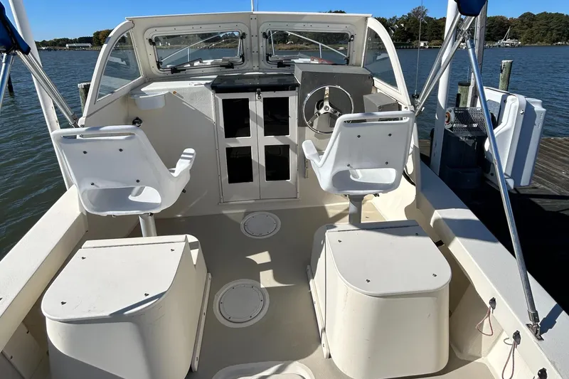 Slide: The Image of 2014 Seaway 21 Seafarer Cuddy boat interior with dual white seats and steering wheel. - 16