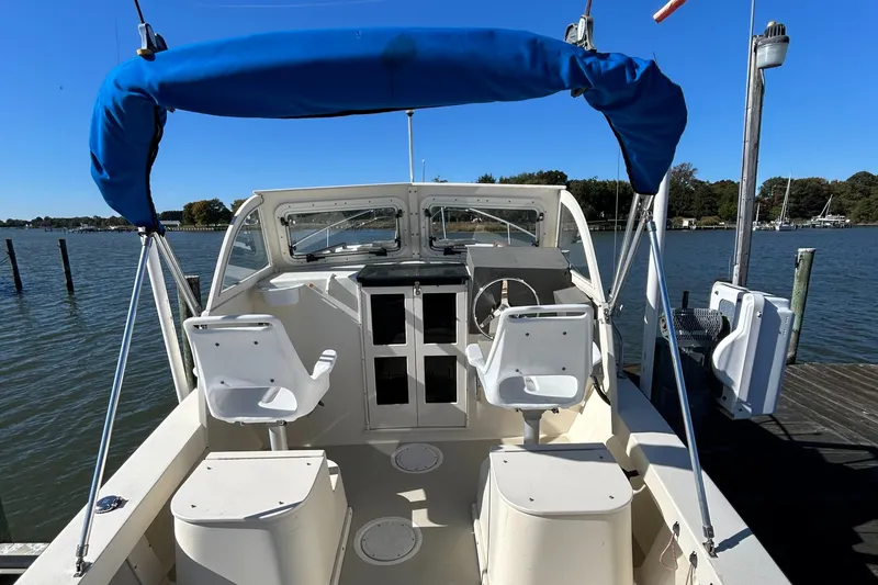Slide: The Image of 2014 Seaway 21 Seafarer Cuddy boat with blue canopy docked on a sunny day. - 17