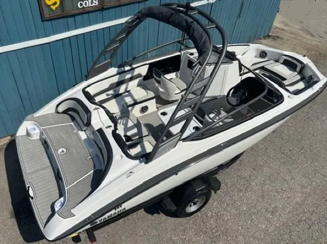 Slide: The Image of 2020 Yamaha Boats 195S, sleek white design, spacious interior, parked on trailer. - 0
