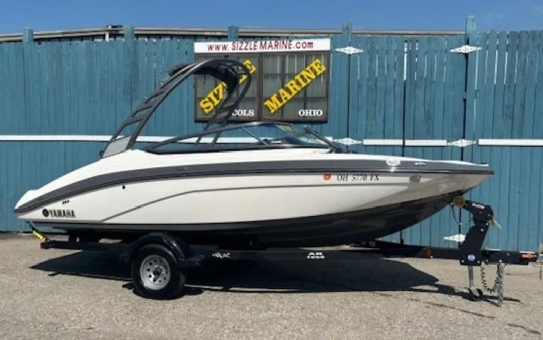Slide: The Image of 2020 Yamaha Boats 195S on trailer, parked in front of Sizzle Marine sign. - 1