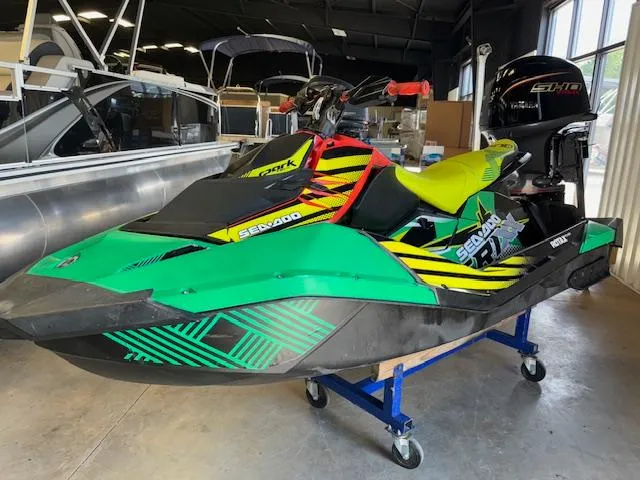 Slide: The Image of 2021 Sea-Doo SPARK TRIXX 3up jet ski in vibrant green and yellow, displayed indoors. - 3