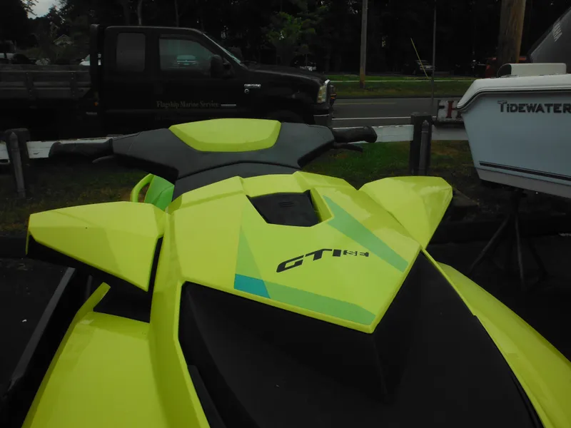 Slide: The Image of 2019 Sea-Doo GTI SE 155 jet ski in bright yellow, parked outdoors. - 14