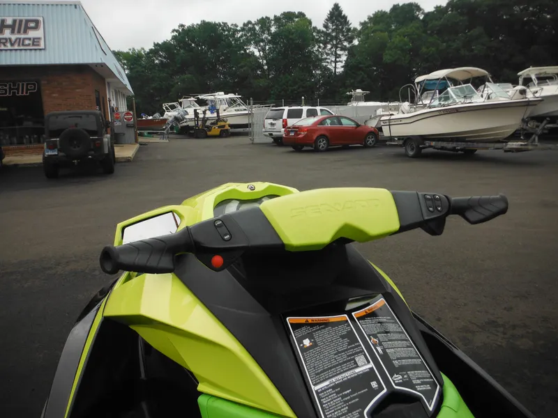 Slide: The Image of 2019 Sea-Doo GTI SE 155 jet ski parked near boats and vehicles at a service shop. - 17