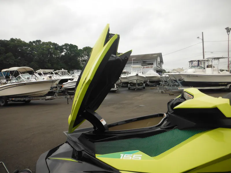 Slide: The Image of 2019 Sea-Doo GTI SE 155 with open storage compartment, surrounded by boats in a marina. - 21