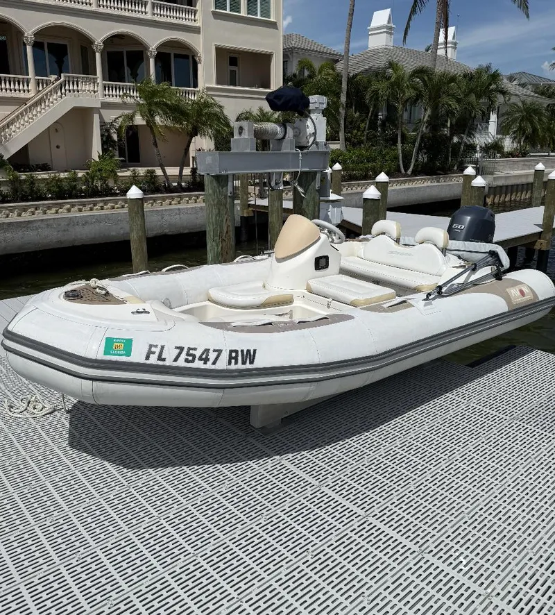 Slide: The Image of 2018 Zodiac Avon inflatable boat docked near luxury waterfront home. - 2