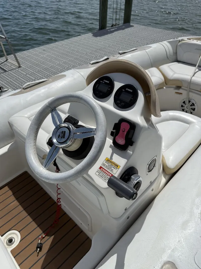 Slide: The Image of 2018 Zodiac Avon boat steering console with controls and gauges, docked by the water. - 4