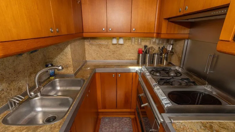 Slide: The Image of Compact kitchen in 2003 Nautor Swan 100 Pilothouse yacht with wooden cabinets and stainless steel appliances. - 29