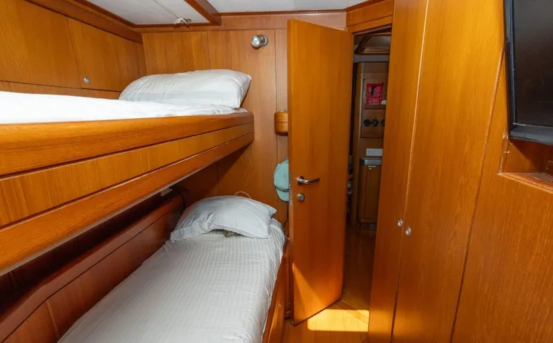 Slide: The Image of Interior of 2003 Nautor Swan 100 Pilothouse with wooden bunk beds and open door. - 45