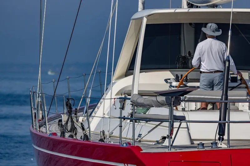 Slide: The Image of Sailor steering 2003 Nautor Swan 100 Pilothouse yacht on calm sea. - 7