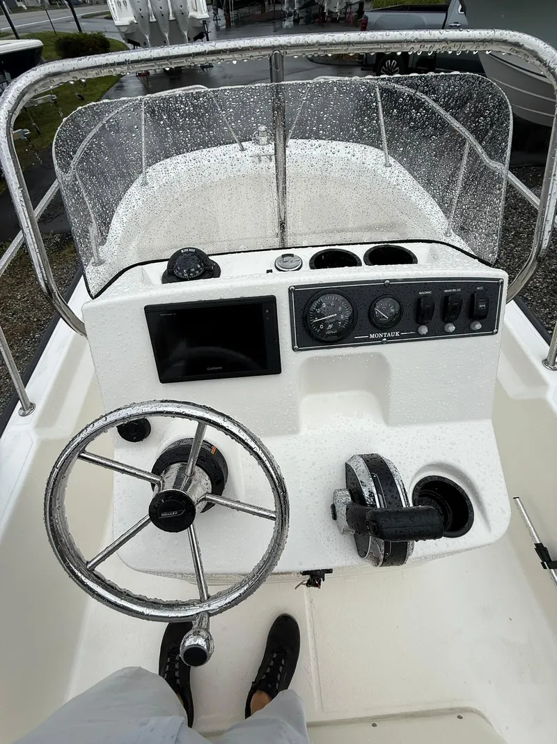Slide: The Image of 2019 Boston Whaler 150 Montauk boat console with steering wheel and controls. - 10