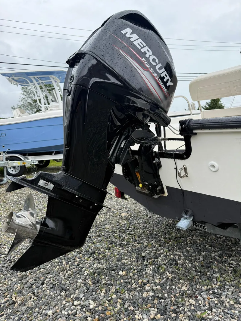 Slide: The Image of 2019 Boston Whaler 150 Montauk with Mercury outboard motor on gravel surface. - 12