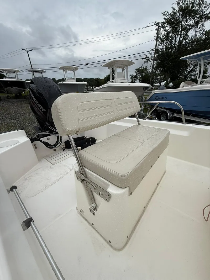 Slide: The Image of 2019 Boston Whaler 150 Montauk boat interior with seating and Mercury engine. - 7