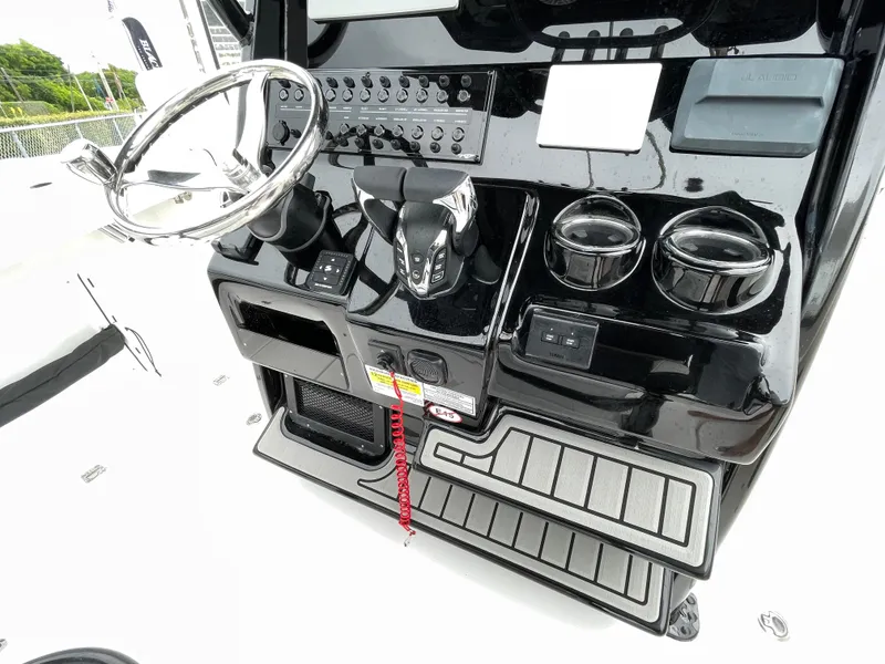 Slide: The Image of 2026 Tidewater 256 CC Adventure boat console with steering wheel and controls. - 13
