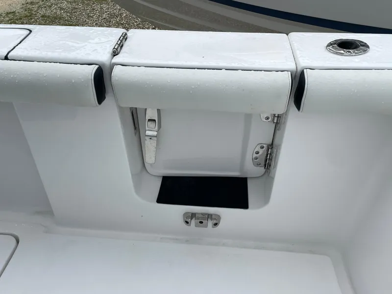 Slide: The Image of 2026 Tidewater 256 CC Adventure boat interior with storage compartment and rod holder. - 25
