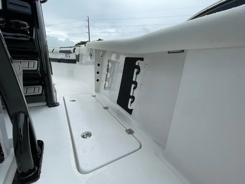 Slide: The Image of 2026 Tidewater 256 CC Adventure boat interior with sleek white design and storage compartments. - 26