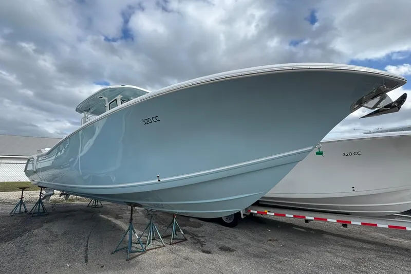 Slide: The Image of 2025 Tidewater 320 CC Adventure boat in a marina, surrounded by other vessels. - 37