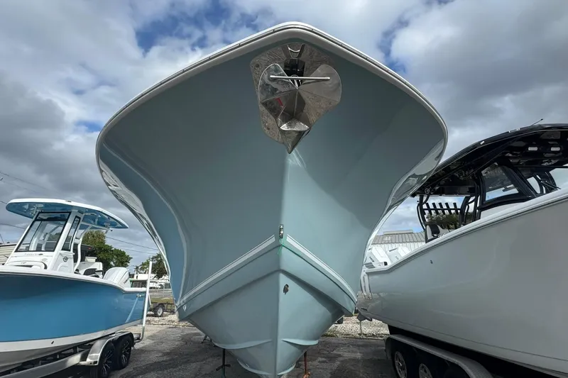 Slide: The Image of 2025 Tidewater 320 CC Adventure boat anchor compartment, open lid, docked in a marina. - 38