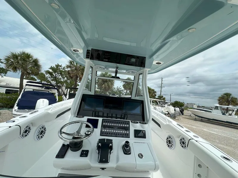 Slide: The Image of 2025 Tidewater 320 CC Adventure boat with dual Mercury engines, docked outdoors. - 9