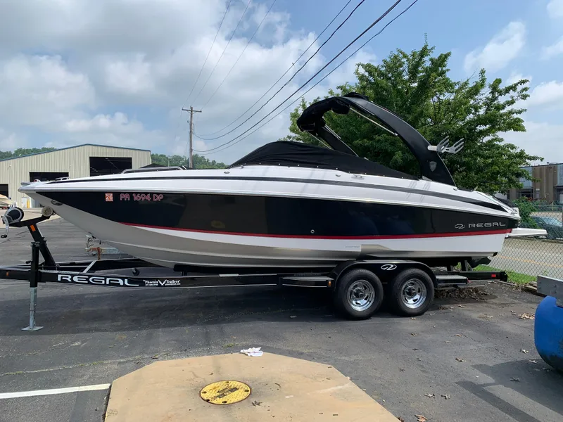 Slide: The Image of 2014 Regal 27 FasDeck boat on trailer, parked outdoors under cloudy sky. - 18