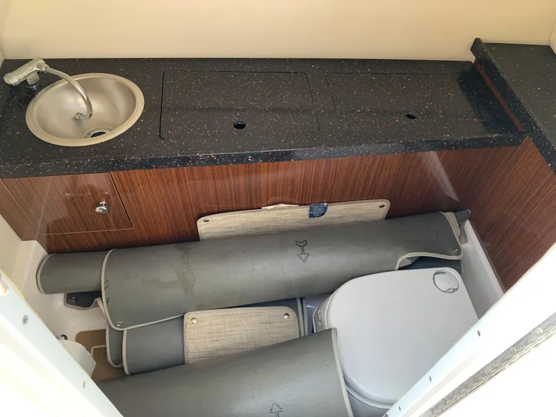 Slide: The Image of 2014 Regal 27 FasDeck boat interior with sink, countertop, and storage area. - 5